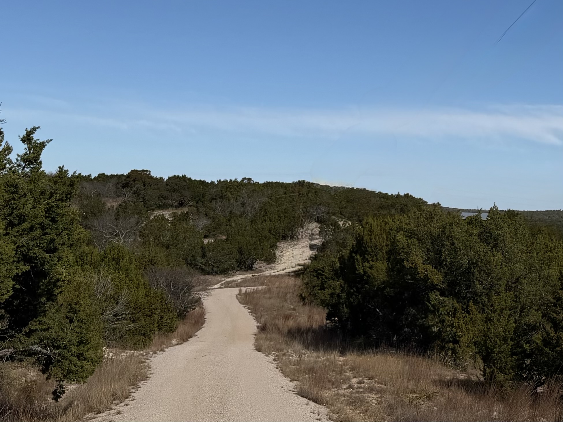 Gravel road leading leading through Texas Hill Country landscape